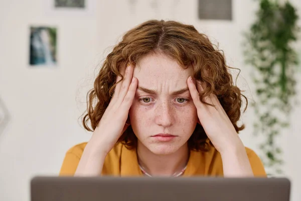 年轻的女性自由撰稿人 紧张的面部表情 坐在工作场所边看电脑屏幕边分析信息 — 图库照片
