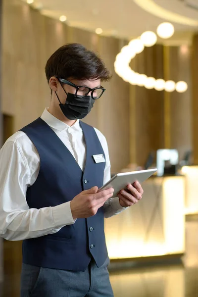 Recepcionista Masculino Uniforme Máscara Protetora Verificando Reservas Line Quartos Hotel — Fotografia de Stock