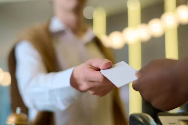 非洲裔美国女接待员登记后手持钥匙卡的年轻男性游客或酒店客人的手 — 图库照片