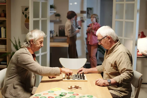 Two Friendly Senior Men Sitting Table Living Room Playing Chess — Stock Photo, Image
