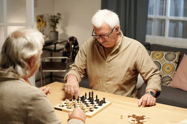 Один Двух Старших Приятелей Двигающих Черную Шахматную Фигуру Вдоль Шахматной — стоковое фото