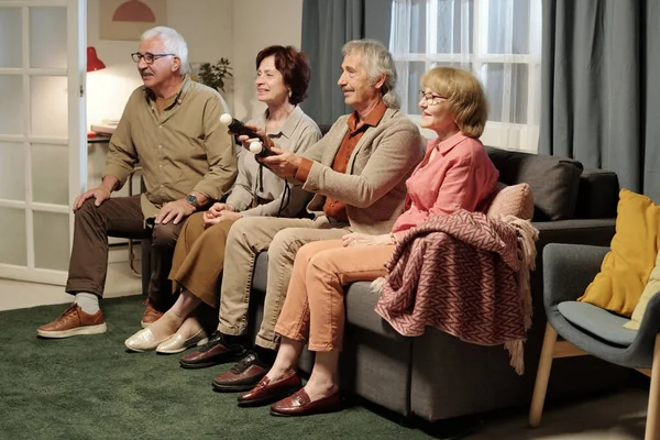 Grupo Cuatro Amigos Mayores Sentados Sofá Frente Televisión Mientras Juegan —  Fotos de Stock