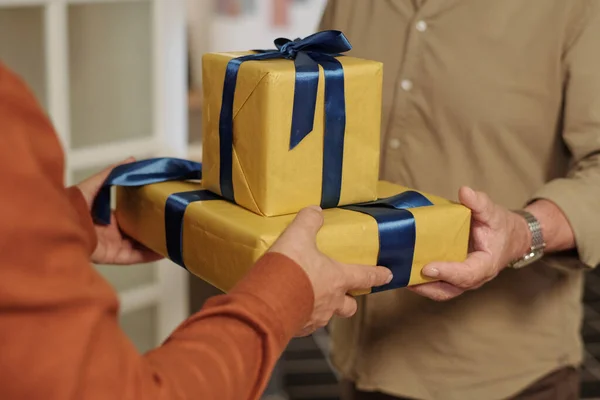 Dłonie Seniora Podającego Pudełko Zapakowane Żółty Papier Prezentem Urodzinowym Dla — Zdjęcie stockowe