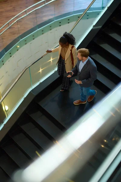 View Two Young Intercultural Colleagues Formalwear Moving Downstairs Staircase Discussing — Stock Photo, Image