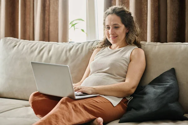 ネットワーク中の画面を見ながらノートパソコンのキーパッドに入力する幸せな若い妊婦や女性のフリーランサー — ストック写真