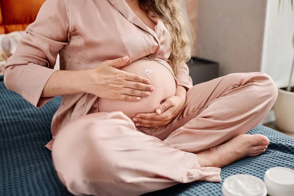 Kobieta Ciąży Jedwabnej Piżamie Stosująca Krem Nawilżający Brzuch Przed Snem — Zdjęcie stockowe