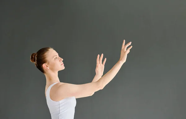 Młoda Tancerka Baletowa Białym Stroju Trzymająca Ramiona Podniesione Podczas Ćwiczeń — Zdjęcie stockowe