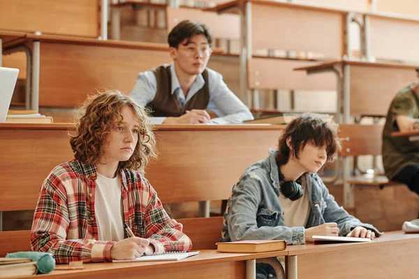 Gruppe Jugendlicher Gemischtrassischer Studenten Freizeitkleidung Die Langen Schreibtischen Hörsaal Notizen — Stockfoto