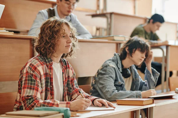Estudiante Joven Serio Mirando Pizarra Escuchando Profesor Mientras Está Sentado — Foto de Stock