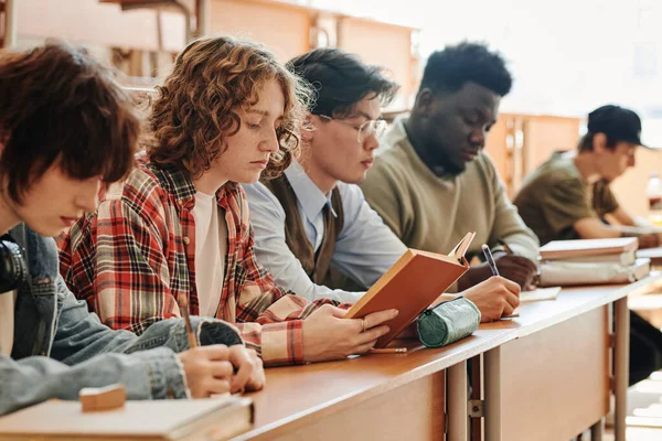 Üniversitenin Ciddi Çok Kültürlü Genç Öğrencileri Derste Masanın Başında Oturup — Stok fotoğraf