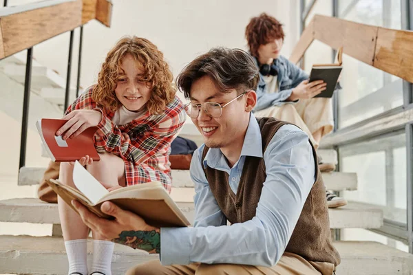 Glückliches Teenager Paar Oder Klassenkameraden Freizeitkleidung Lesen Buch Während Sie — Stockfoto