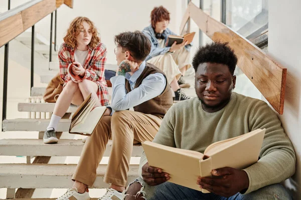 Seriöser Afroamerikanischer Teenager Freizeitkleidung Liest Buch Gegen Seine Klassenkameraden Die — Stockfoto
