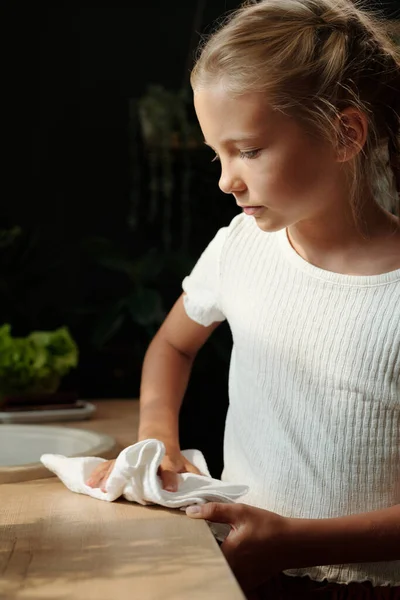 身穿白色T恤衫的年轻女孩在早餐后清扫厨房桌子 或在家务活中以棉布餐巾做饭 — 图库照片