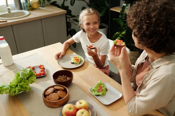 Neşeli Genç Kız Lezzetli Sandviçler Yiyip Annesine Bakarken Ikisi Mutfak — Stok fotoğraf