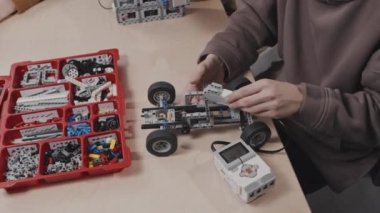 Genç çocuk ve sınıf arkadaşları okulda modern robotik derslerine katılıp projeleri üzerinde çalışıyorlar.
