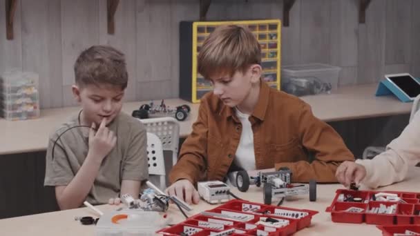 Zwei Kaukasische Jungen Bauen Gemeinsam Ein Roboterauto Modell Während Des — Stockvideo