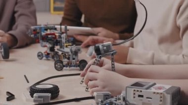 Tabletin başında oturan çocukların seçici odak noktası okulda ders sırasında robotik modeller üzerinde çalışmaları.