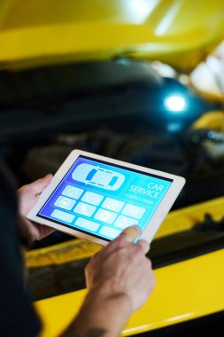 Web sitesinin ana sayfasını ziyaret ederken tablet ekranındaki simgeye işaret eden genç bakım servisi mühendisinin eli