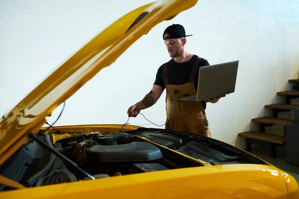 Mecânico Jovem Com Laptop Instalando Fios Motor Carro Durante Realização — Fotografia de Stock