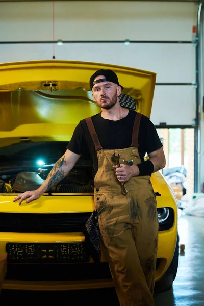 Jovem Trabalhador Sério Serviço Manutenção Carro Por Automóvel Cor Amarela — Fotografia de Stock