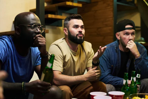 Gespannte Interkulturelle Freunde Mit Bier Tisch Sitzen Und Die Übertragung — Stockfoto