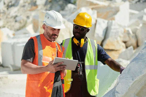 Dos Ingenieros Masculinos Interraciales Sombreros Uniformes Mirando Pantalla Tableta Mientras —  Fotos de Stock