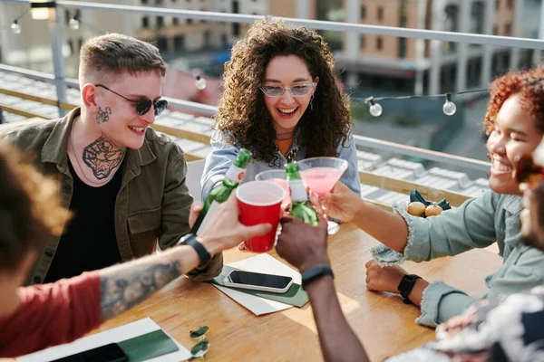 Feliz Joven Interracial Amigos Tintineando Con Sus Bebidas Sobre Mesa —  Fotos de Stock
