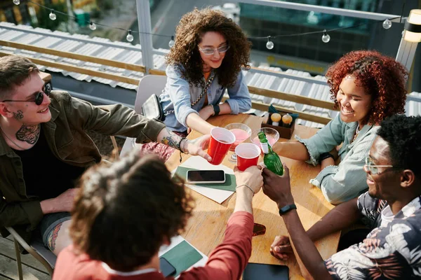 Cinco Alegres Amigos Jóvenes Tintineando Con Sus Bebidas Sobre Mesa —  Fotos de Stock
