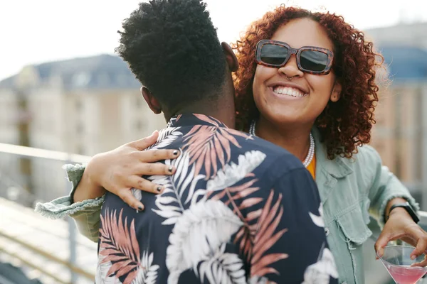 年轻快乐的黑人女人戴着太阳镜拥抱着非洲裔美国男人 同时享受着屋顶派对 — 图库照片