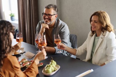 Mutlu ebeveynler ve şampanya kadehleri olan iki kız arkadaş ya da nişan törenini masada oturarak kutluyorlar.