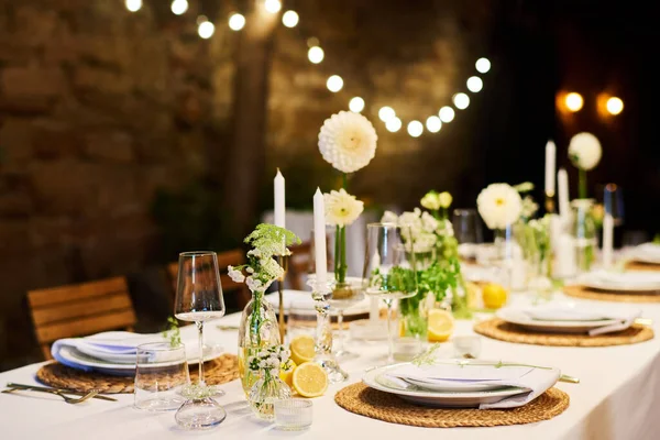 キャンドルを囲むナプキン付きプレートの2行 花瓶や結婚式のごちそうのために準備ワイングラスの花とお祭りテーブル — ストック写真