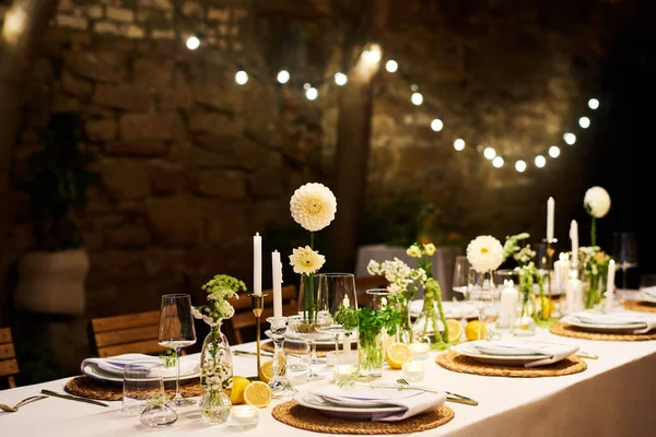 Serveras Middagsbord Med Tallrikar Servetter Vinglas Blommor Och Ljus Förberedda — Stockfoto