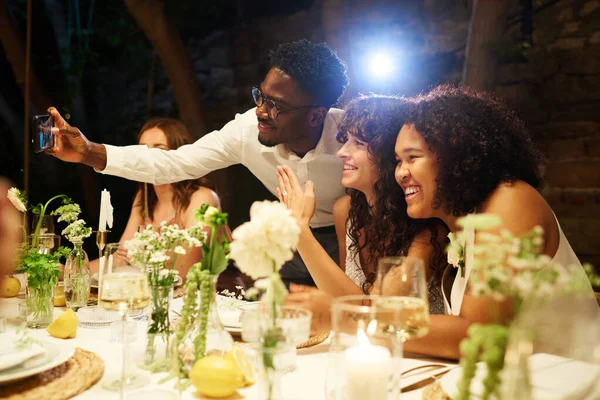 年轻的黑人男子与快乐的多文化女同性恋新娘举行婚宴 他们带着结婚戒指在餐桌前自夸 — 图库照片
