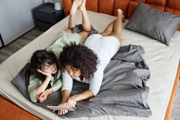 Tabletli Iki Genç Kız Arkadaşın Hafta Sonları Çift Kişilik Yatakta — Stok fotoğraf