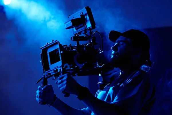 Giyim Kuşamında Genç Bir Kameraman Karanlık Odada Ticari Video Çekiyor — Stok fotoğraf