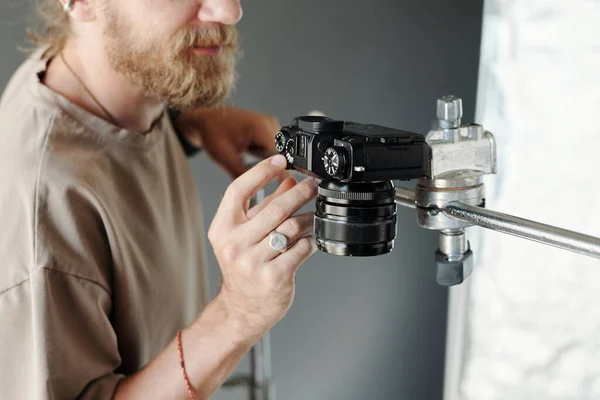 撮影の準備をしながら 若い現代のカメラマンの手は 定盤の設定を調整し 金属スライダーに固定します — ストック写真