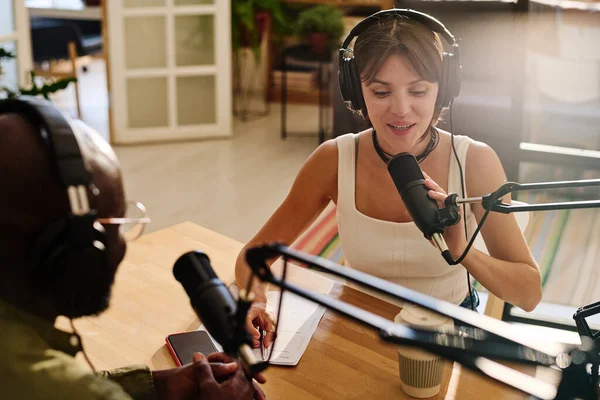 Young Woman Talking Microphone While Sitting Desk Front Black Man — Stock Photo, Image