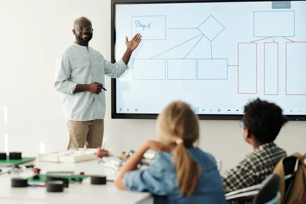 Young Confident Teacher Standing Whiteboard Front Elementary Learners Explaining Them — Stock Photo, Image