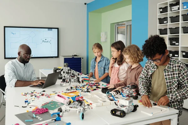 Grupp Mångkulturella Skolbarn Står Framför Afroamerikansk Lärare Robotik Skriva Laptop — Stockfoto