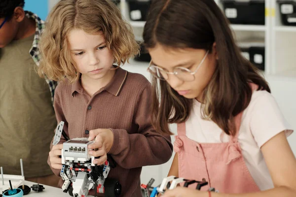 Schattige Sesrious Schooljongen Kijken Naar Zijn Klasgenoot Bouwen Robot Terwijl — Stockfoto