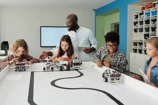 Jovem Professor Robótica Com Tablet Ajudando Escolares Controlar Seus Robôs — Fotografia de Stock