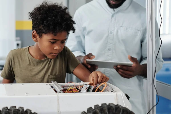 Oyuncak Robot Kablolarını Bağlayan Sevimli Afrikalı Amerikalı Öğrenci Robot Öğretmeninin — Stok fotoğraf