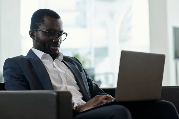 Jovem Funcionário Afro Americano Sério Com Laptop Seus Joelhos Rede — Fotografia de Stock