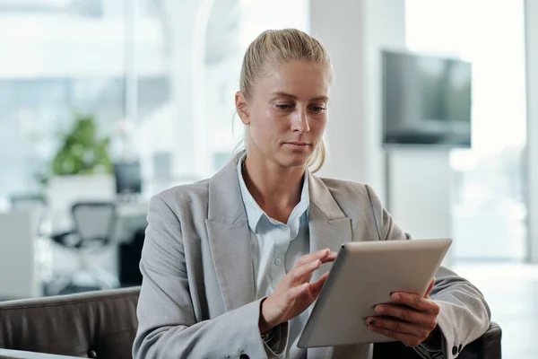 Young Blond Business Coach Grey Formalwear Scrolling Tablet While Sitting — Stock Photo, Image