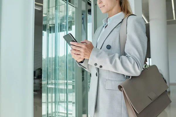 Modern Ofis Merkezinde Dururken Omzunda Deri Çantasıyla Akıllı Telefonuyla Mesajlaşan — Stok fotoğraf