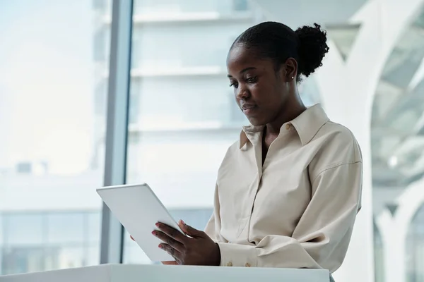 Młody Poważny Afroamerykańska Analityk Tabletem Siedzi Biurze Przed Dużym Oknem — Zdjęcie stockowe