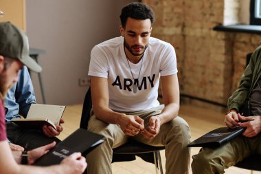 Travma sonrası sendromu olan çok ırklı bir genç, diğer insanların arasında oturup onun hikayesini dinliyor.