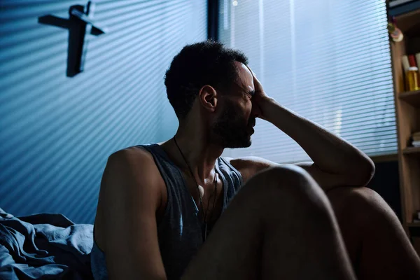 Ung Stressad Man Vidrör Huvudet När Han Sitter Vid Sängen — Stockfoto