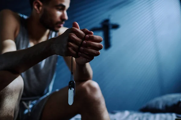Руки Молодого Безсоння Чоловік Тримає Срібний Ланцюг Медальйонами Сидячи Ліжку — стокове фото