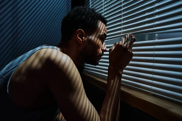 Oldalnézet Fiatal Álmatlan Férfi Néz Velencei Redőnyök Ablakon Miközben Settenkedik — Stock Fotó